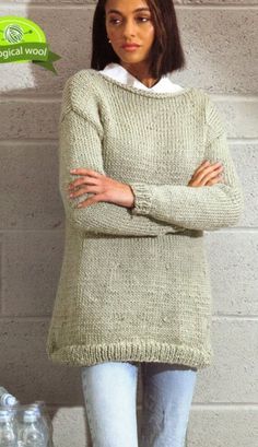 a woman standing in front of a brick wall with her arms crossed and looking at the camera