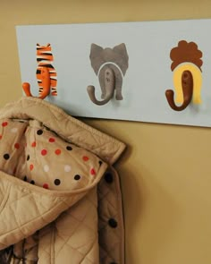 there are three animal magnets on the wall above a baby's crib