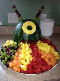 a platter filled with lots of different fruits and veggies in the shape of a caterpillar