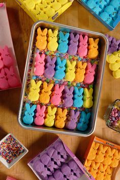 a tin filled with lots of different colored peep - poop cookies on top of a wooden table