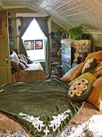 an attic bedroom with bed, couch and television in the corner is furnished with plush furniture