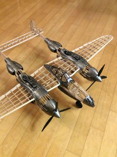 two model airplanes are sitting on the wooden floor in front of each other and one is upside down