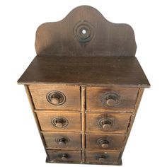 an old wooden cabinet with four drawers on one side and three knobs on the other