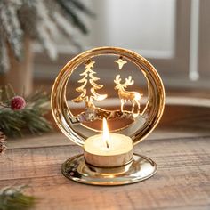 a candle that is sitting on top of a table with christmas decorations in the background