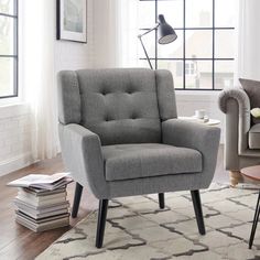 a living room with a gray chair and white rug