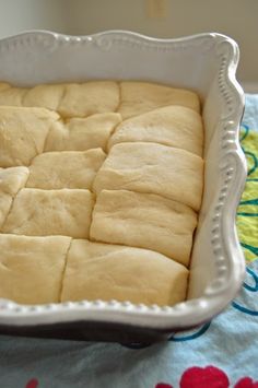 a pan filled with bread sitting on top of a blue and white cloth covered table