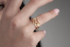 a close up of a person wearing a gold ring with an elephant head on it