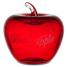 a red glass apple with the word bad apple written in cursive writing on it