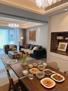 a living room filled with lots of furniture and food on top of a wooden table