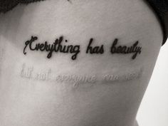 a woman with a tattoo saying everything has beauty