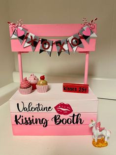 a valentine's kissing booth with cupcakes and decorations