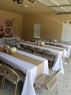 several tables are set up with white tablecloths and gold place settings for an event