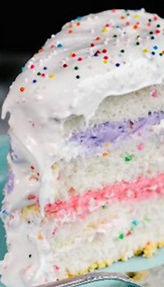 a slice of cake with white frosting and colorful sprinkles