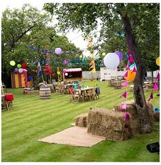 an outdoor party with hay bales and balloons