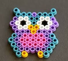 an owl made out of plastic beads on a table