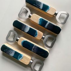 four wooden and metal bottle openers sitting next to each other on top of a table