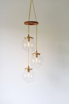 three glass globes hanging from a brass chandelier