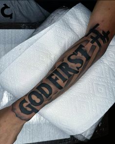 a man's arm with the words god first on it