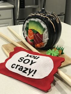 there is a sushi roll and chopsticks on the table with a sign that says you soy crazy