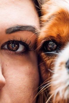 a close up of a woman with her dog's face next to her eyes