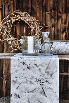 a table topped with candles and vases next to a wreath