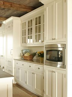 a kitchen with white cabinets and silver appliances