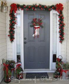 the front door is decorated for christmas with stockings and poinsettis