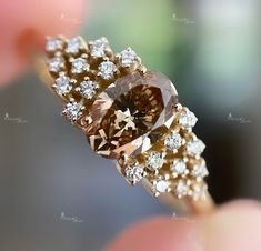 a fancy ring with an orange diamond surrounded by small white and brown diamonds on it