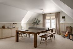 a room with a ping pong table in the center and two chairs around it