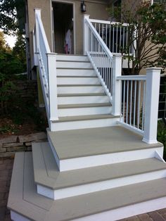 a white porch with steps leading up to the front door