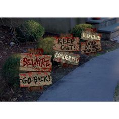 several signs on the side of a road that say danger, beware, and go back