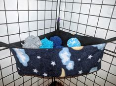 a basket filled with blue and white items on top of a tiled floor next to a wall