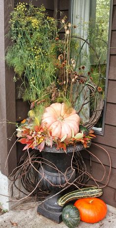 pumpkins and gourds are sitting on the porch