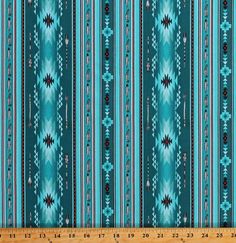 a blue and green striped fabric with an intricate design on the bottom, in front of a ruler