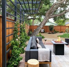 an outdoor living area with couches, tables and a fire pit in the middle