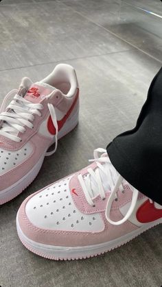 a pair of pink and white sneakers on the ground