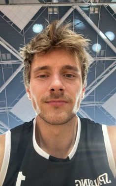 a man in a black and white jersey is posing for a photo with his head tilted to the side