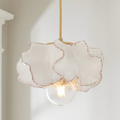 a light fixture hanging from a ceiling with a glass globe in the middle and a white wall behind it