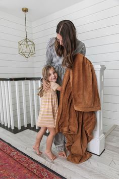 a woman and her daughter are standing on the stairs