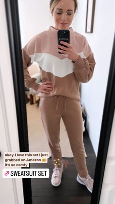 a woman taking a selfie in front of a mirror with the caption, she is wearing sweatsuit set