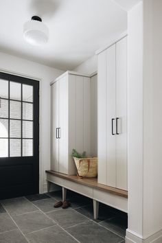 a room with white cupboards and a black door