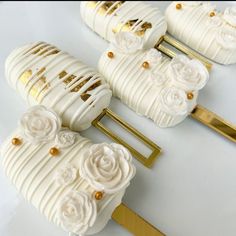 some white and gold decorated desserts with flowers on them