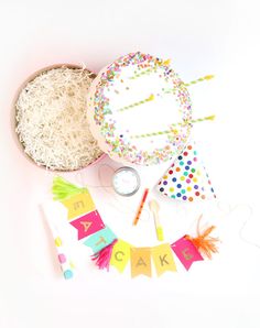 a birthday party with confetti, streamers and cake decorating supplies on a white background