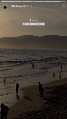 people are walking on the beach at sunset