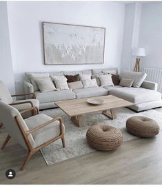 a living room filled with furniture and a large painting on the wall above it's windows