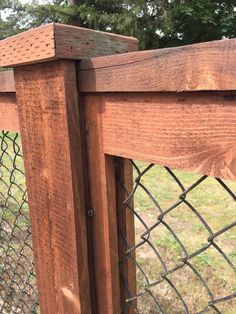 a close up of a wooden fence with grass in the background