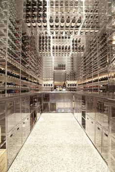 a room filled with lots of wine bottles and glass cases on the walls, along with a carpeted floor