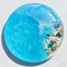 a blue plate with shells and sea glass on it