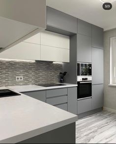 a kitchen with grey cabinets and white counter tops