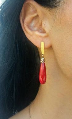 Red coral, drop shaped, dangling from a golden post. The post is engraved , the stone cap is filigree decorated. These red earrings make a great gift for your special woman this holiday season.Elegant, feminine and delicate- they are sure to get a woman noticed.- Made of sterling silver, plated with 24K gold (available in sterling silver as well).- Length- 1/75 inches (4.5 cm).- They are light and comfortable.- Ships within 3 business days.- Arrives in lovely gift box, ready to give to someone s Red Teardrop Pierced Jewelry, Red Drop Jewelry With Matching Earrings, Red Long Drop Earrings With Ear Wire, Red Long Drop Earrings As Gift, Red Long Drop Earrings For Gift, Red Teardrop Jewelry With Matching Earrings, Red Teardrop Earrings For Formal Occasions, Red Drop Earrings For Pierced Ears, Red Drop Earrings For Gift